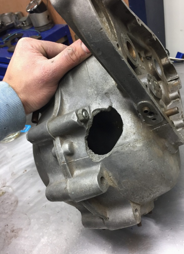 Damaged classic motorcycle engine case with large hole before TIG welding repair